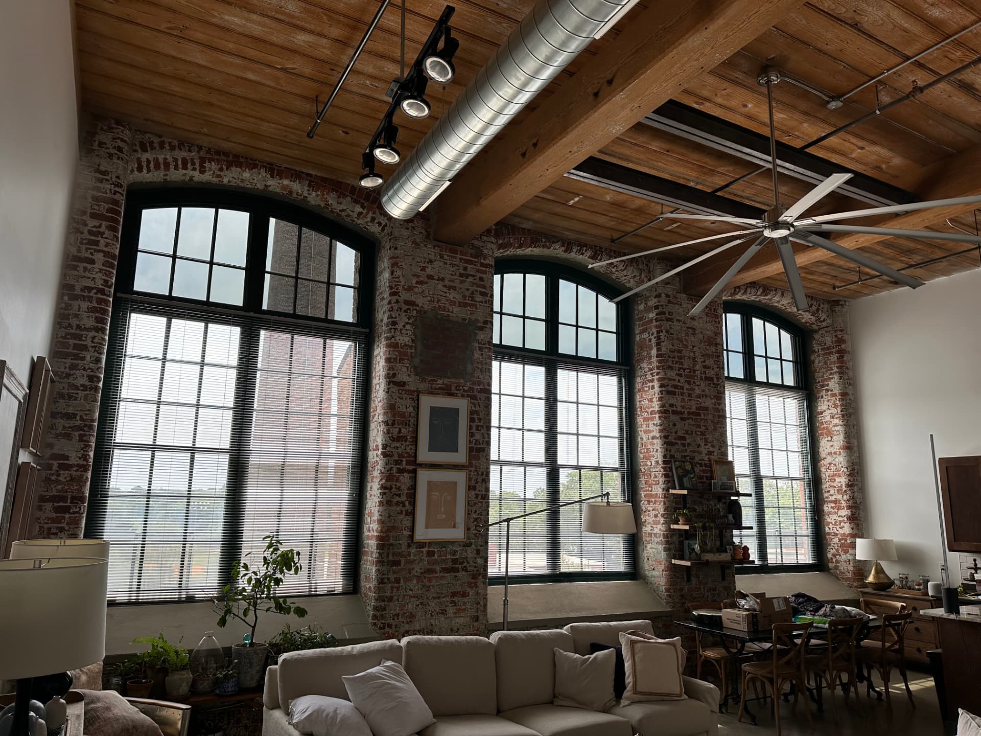 Loft living space with tall arched windows treated with window film